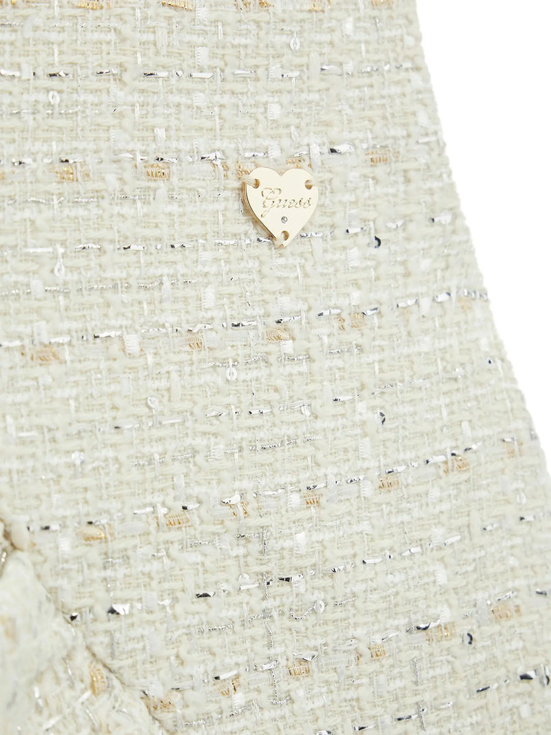 Closer look at the Guess tweed dress showing detail of the gold logo badge.