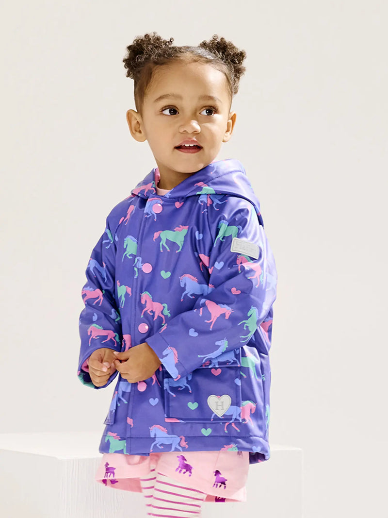 Girl wearing the Hatley hearts & horses raincoat.