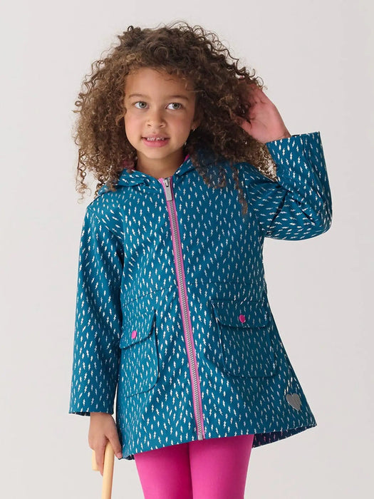 Smiling girl modelling the Hatley lightning bolts raincoat.