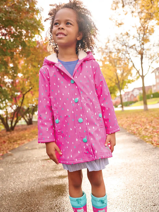 Girl wearing the Hatley rain drops colour changing raincoat.