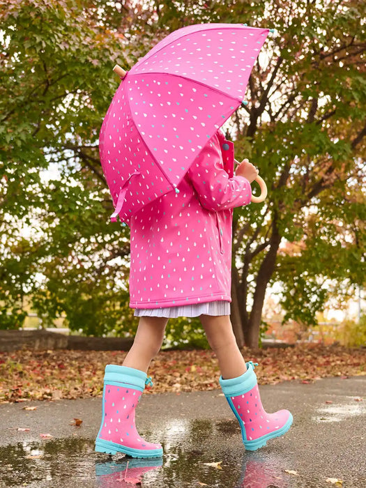 Girl wearing the Hatley rain drops colour changing raincoat.