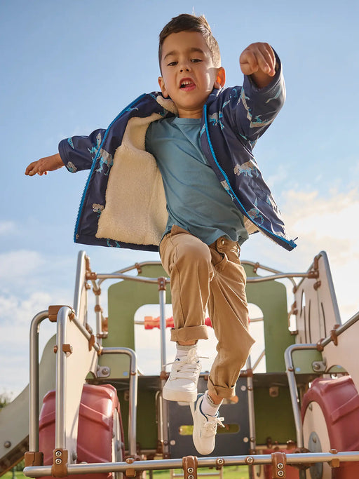 Boy wearing the Hatley t-rex attack raincoat.