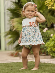 Smiling baby girl modelling the Juliana frilled dress.