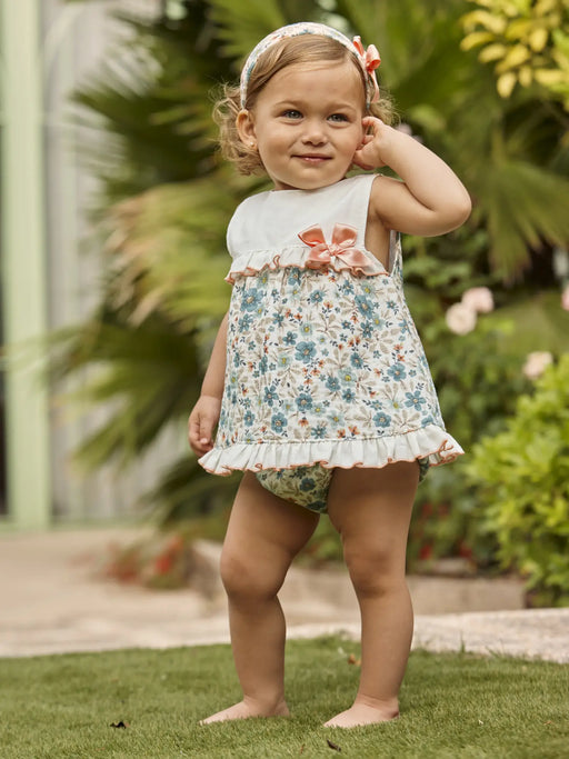 Smiling baby girl modelling the Juliana frilled dress.