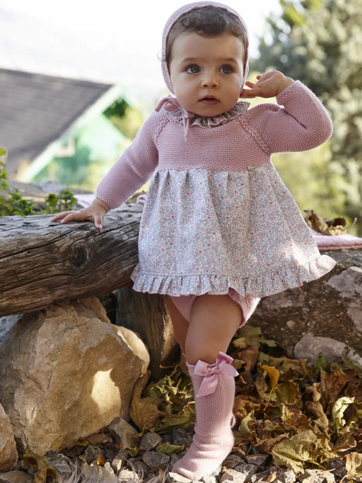 Baby girl modelling the Juliana knitted dress.