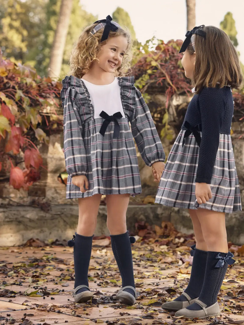 Girl in navy plaid dress by Juliana.