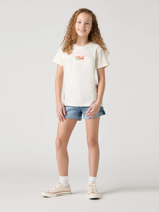 Smiling girl modelling the Levi's denim shorts.