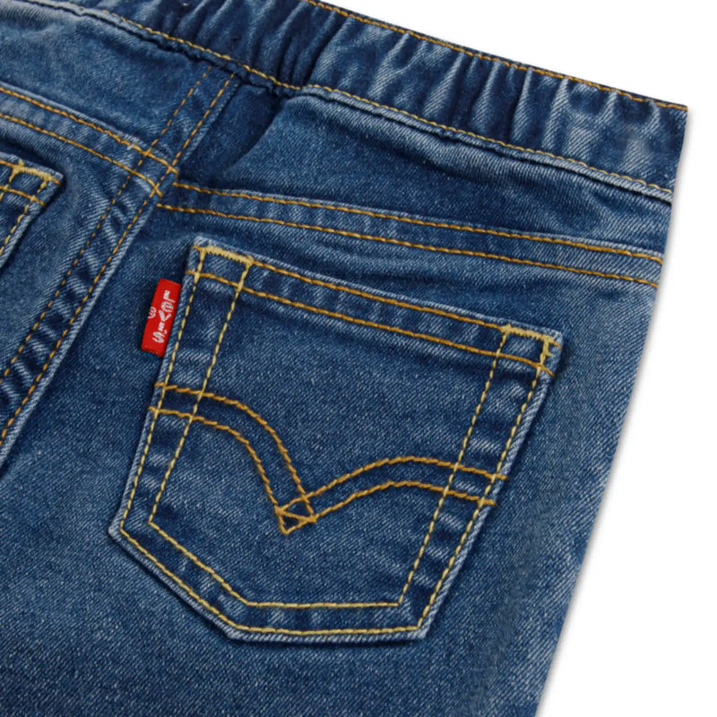 Closer look at the Levi's blue jeans showing detail of the red logo tag on the back pocket.