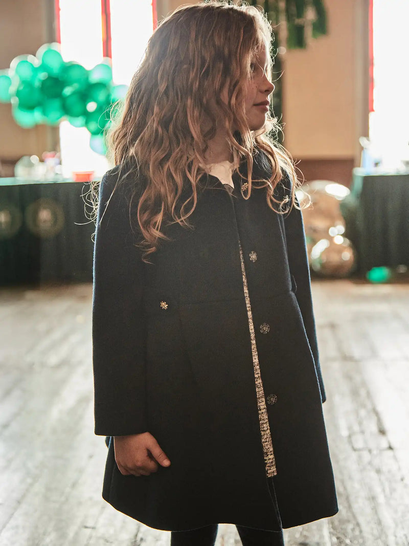 Girl wearing the Mayoral button coat.