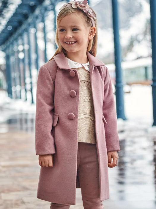 Smiling girl modelling the Mayoral button coat.