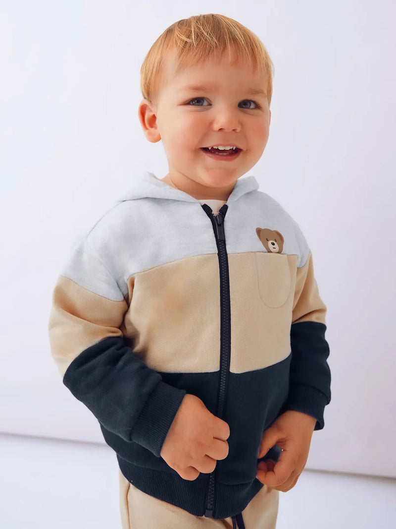 Smiling baby boy modelling the Mayoral colourblock tracksuit.