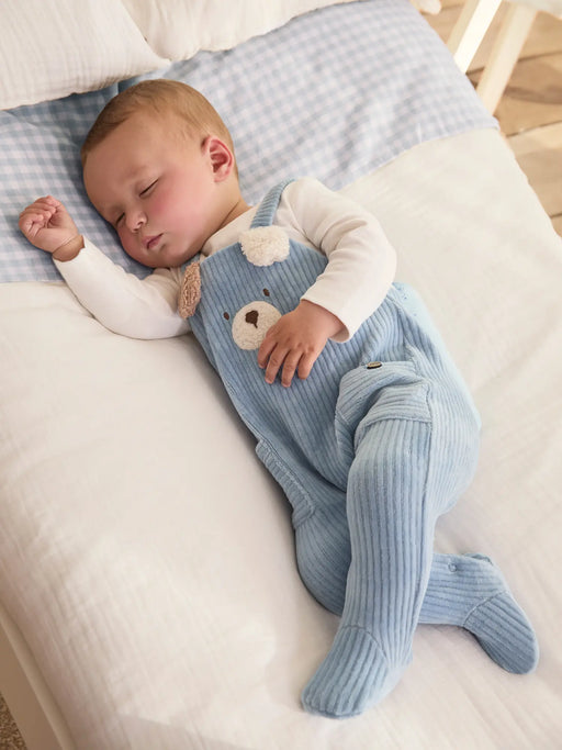 Sleeping baby boy wearing the Mayoral corduroy babygrow.