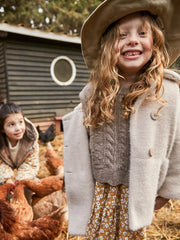 Smiling Girl modelling the Mayoral button coat.