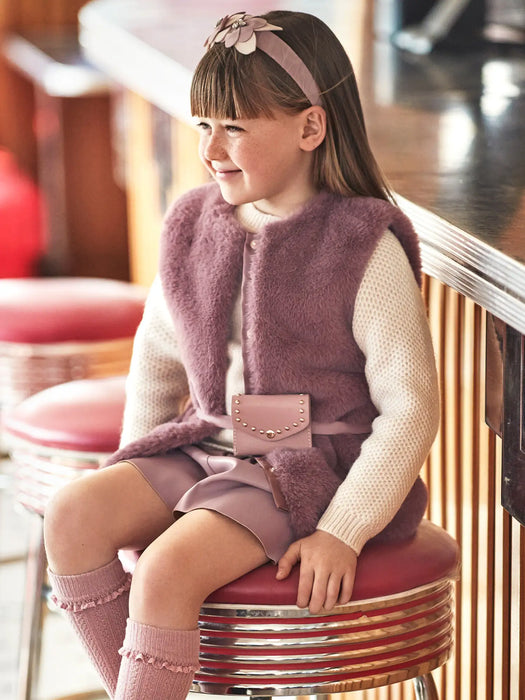 Smiling girl modelling the Mayoral faux fur gilet.