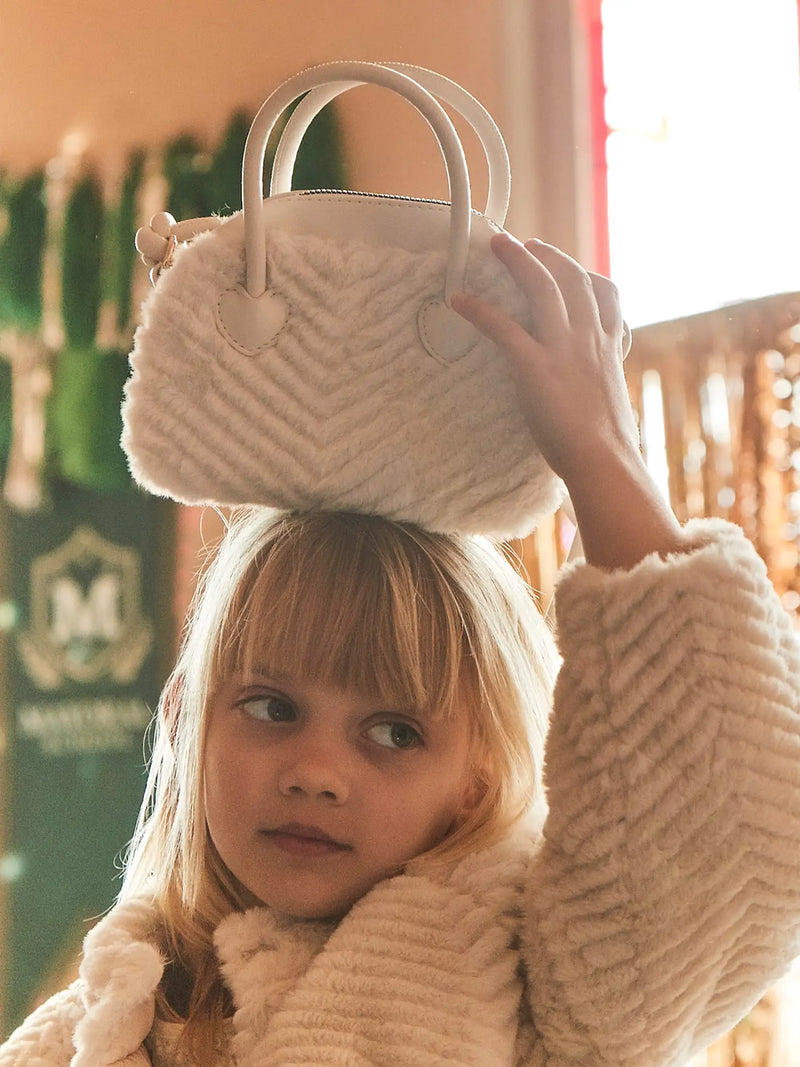 Girl modelling the Mayoral faux fur handbag.