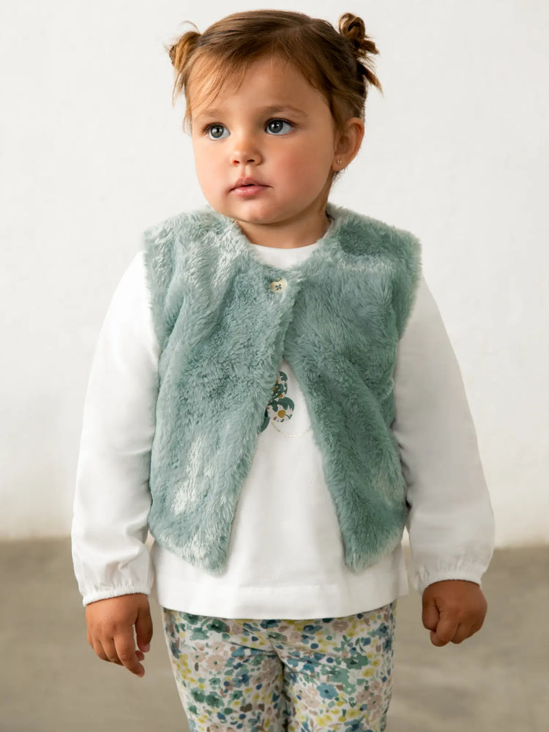 Baby girl in green faux fur vest & leggings set by Mayoral.