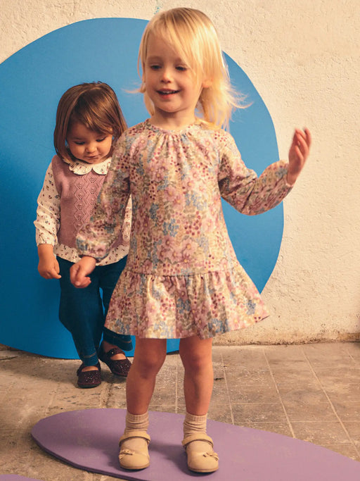 Smiling baby girl modelling the Mayoral floral print dress.