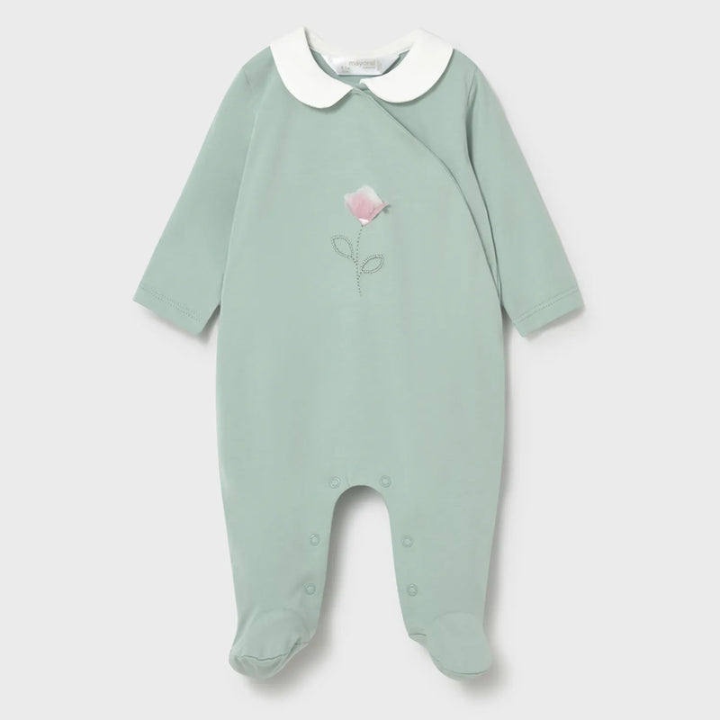 Green babygrow with pink flower on the front.