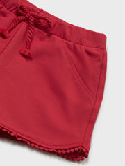 Red shorts with pom pom trim at the hem.