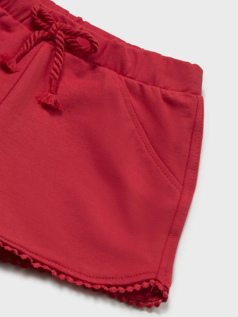 Red shorts with pom pom trim at the hem.