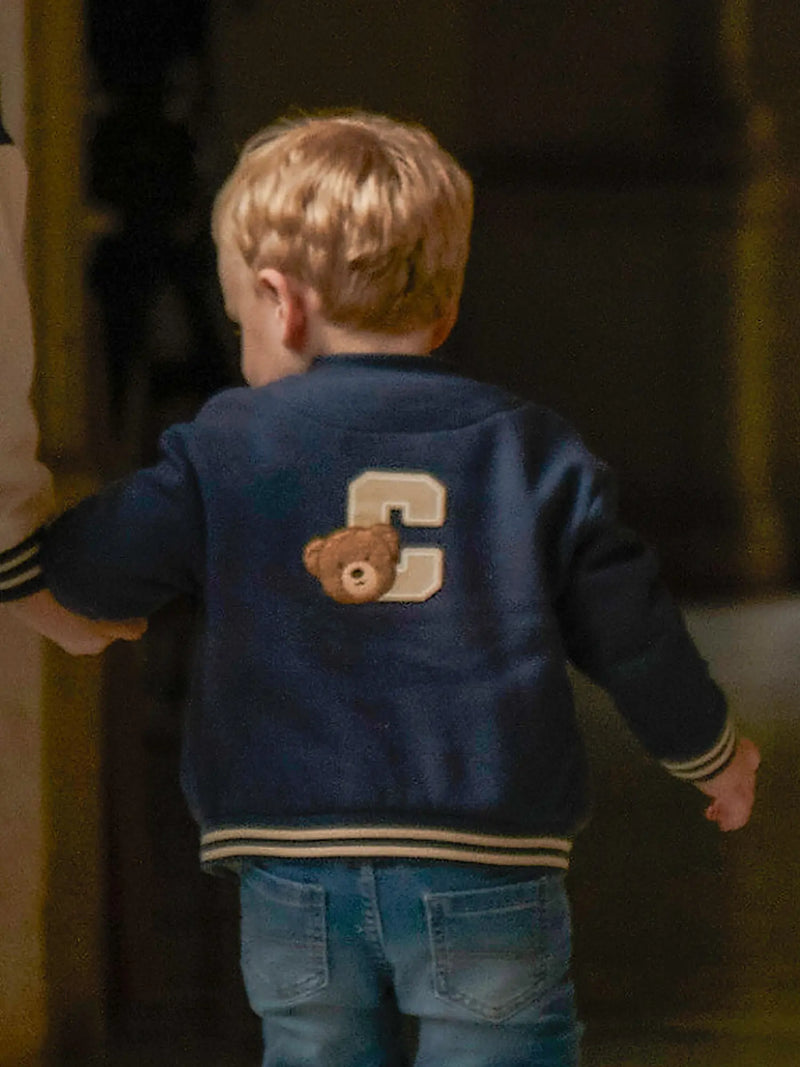 Baby boy in blue varsity jacket by Mayoral.
