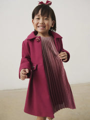 Smiling Girl modelling the Mayoral pleated coat.