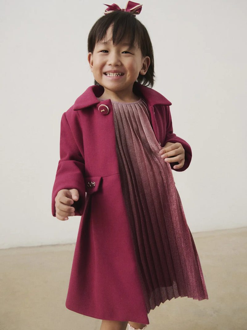 Smiling Girl modelling the Mayoral pleated coat.