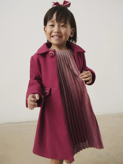 Smiling Girl modelling the Mayoral pleated coat.