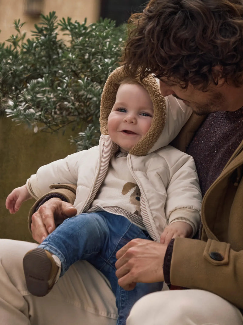 Smiling baby boy modelling the Mayoral reversible coat.