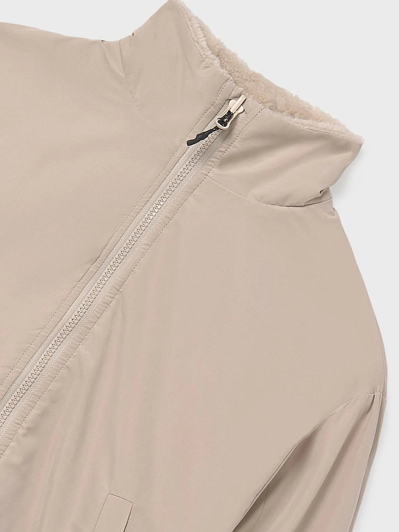 Plain beige side of the girl's reversible jacket.