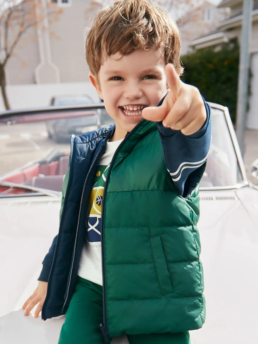 Smiling boy modelling the Mayoral reversible gilet.