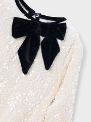 Mayoral sequin dress with black velvet bow at the neck.