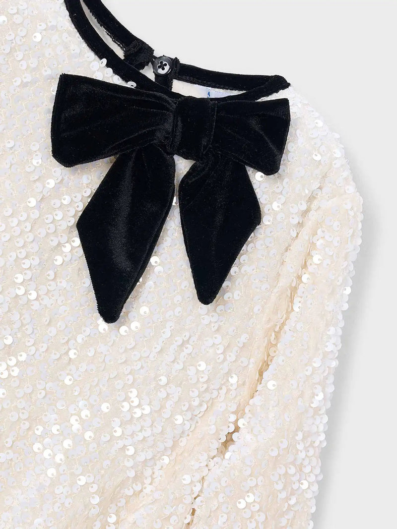 Mayoral sequin dress with black velvet bow at the neck.