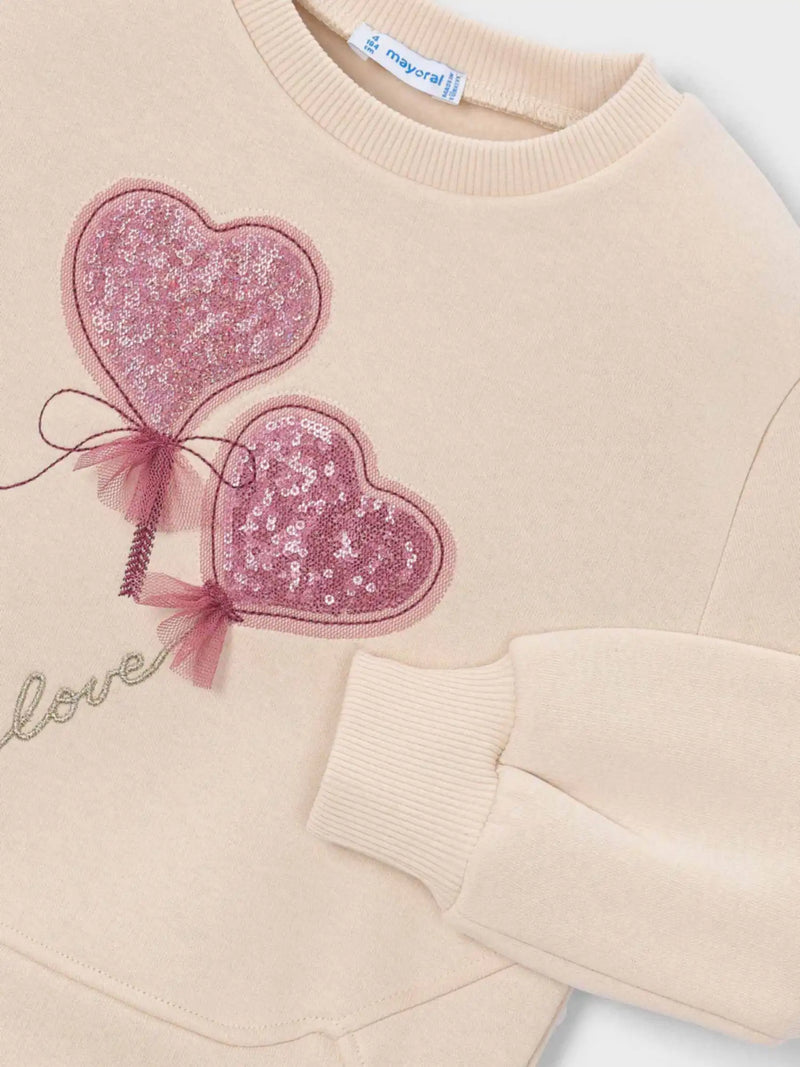 Closer look at the Mayoral beige sweatshirt showing detail of the pink sequin hearts.