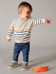 Smiling baby boy modelling the Mayoral skinny fit jeans.