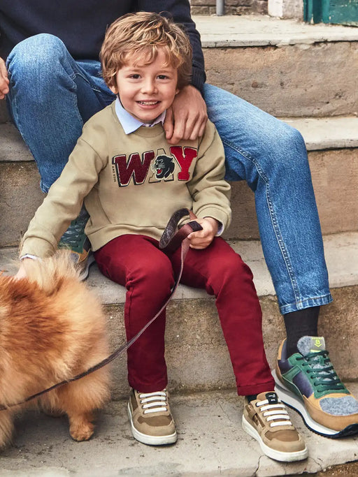 Smiling boy modelling the Mayoral jogger pants.