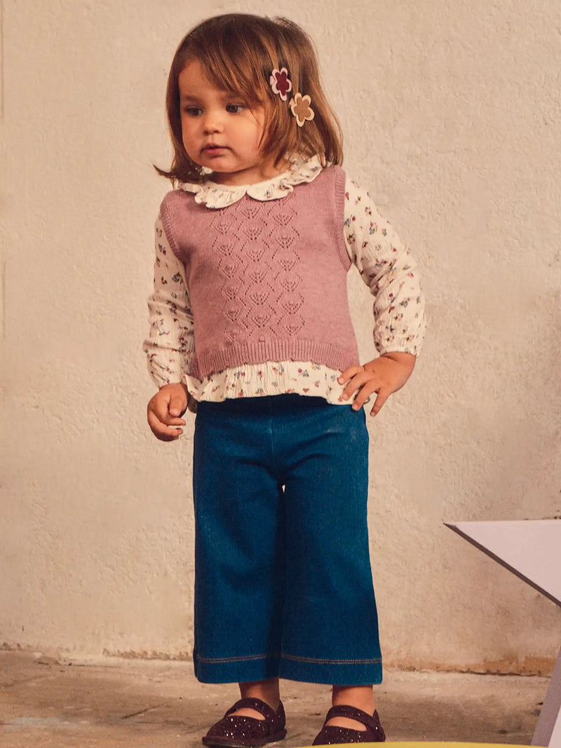 Baby girl modelling the Mayoral vest & jeans set.