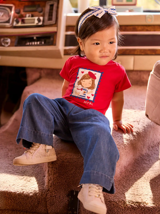 Smiling baby girl modelling the Mayoral jeans & t-shirt set.