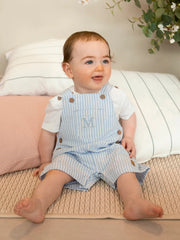 Boy modelling the Mintini Baby striped dungarees.