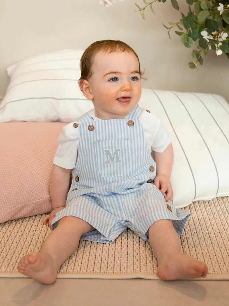 Boy modelling the Mintini Baby striped dungarees.