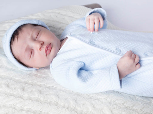 Sleeping baby boy wearing the Mintini Baby waffle babygrow & hat.