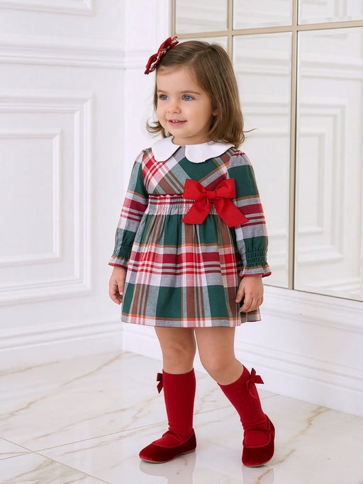 Smiling baby girl modelling the Miranda plaid dress.