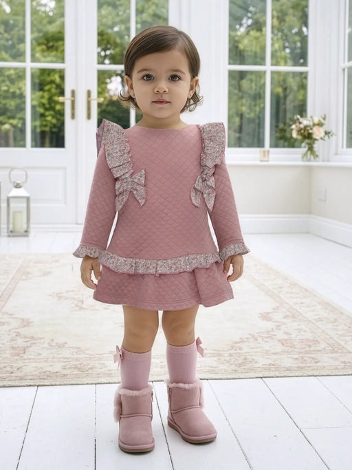 Baby girl wearing the Miranda quilted dress.