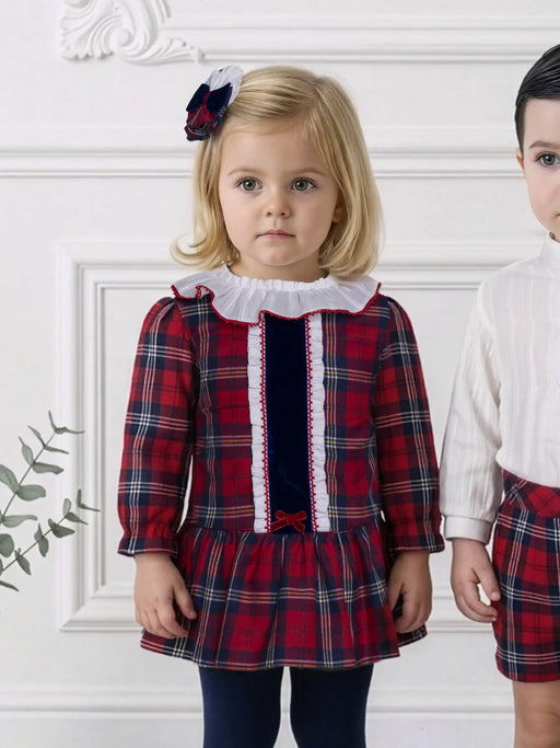 Baby girl in red tartan dress by Miranda.