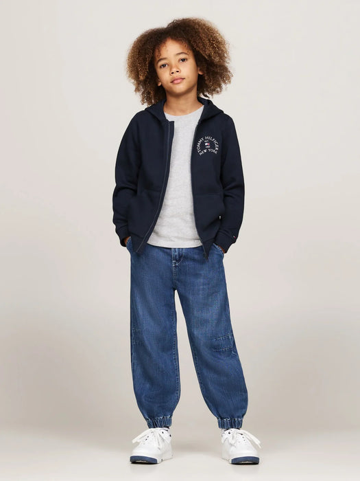 Boy modelling the Tommy Hilfiger arch logo hoodie.