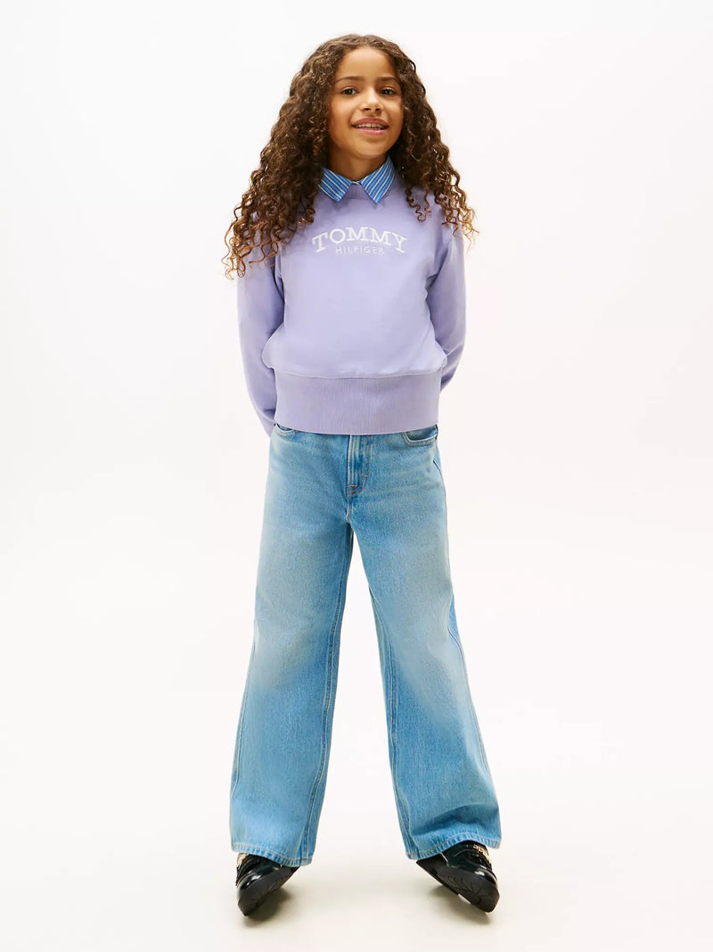 Girl modelling the Tommy Hilfiger arched logo sweatshirt.