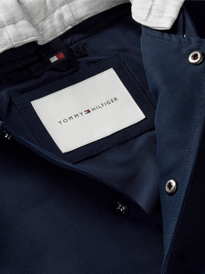 Closer look at the Tommy Hilfiger bomber jacket showing detail of the button fasteners.