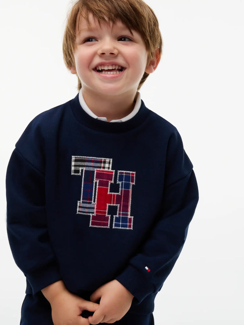 Smiling Boy modelling the Tommy Hilfiger crest tracksuit.