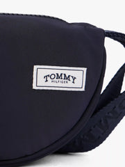 Tommy Hilfiger crossbody moon bag with white logo patch.