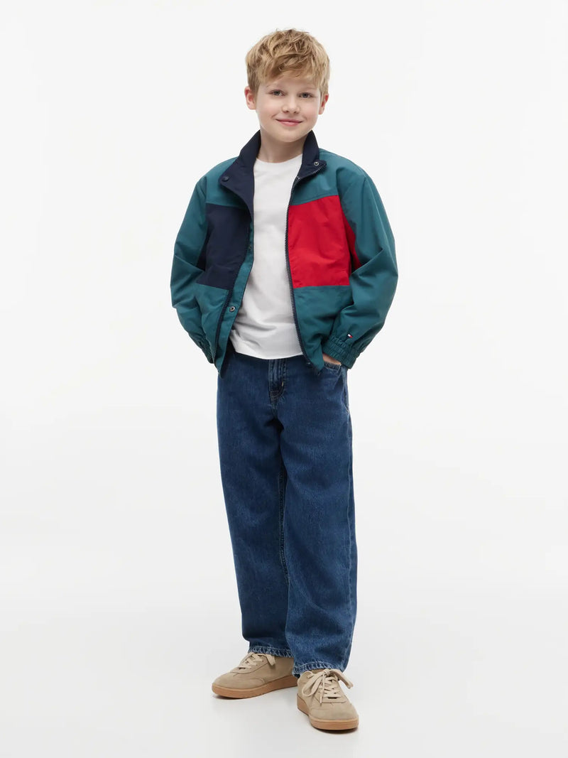 Boy modelling the Tommy Hilfiger reversible jacket.